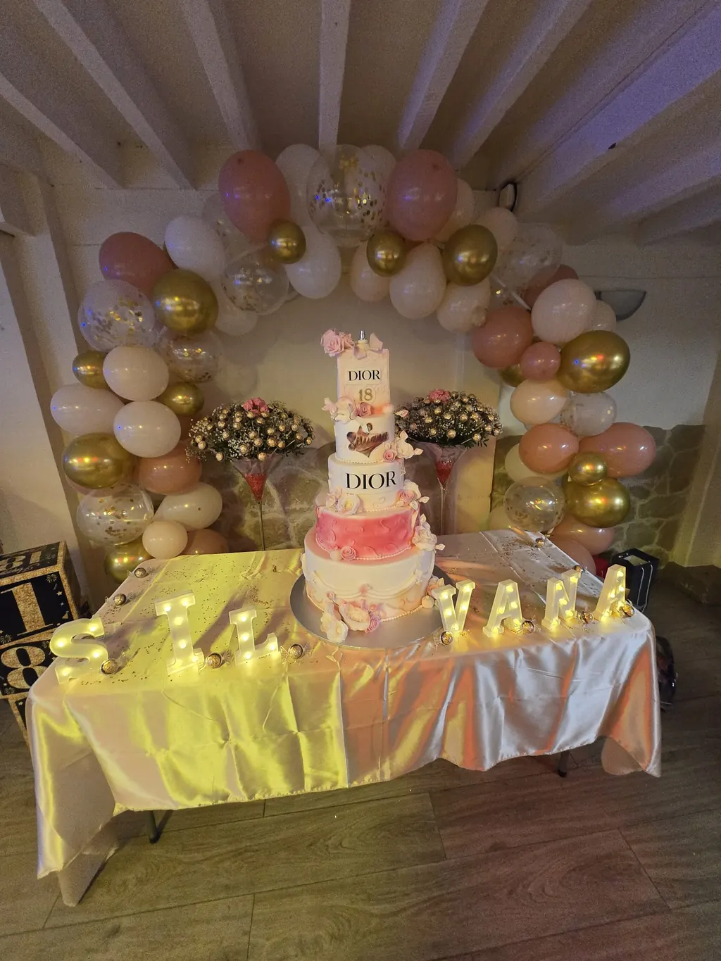 Gâteau d'anniversaire chic et arche de ballons dorés