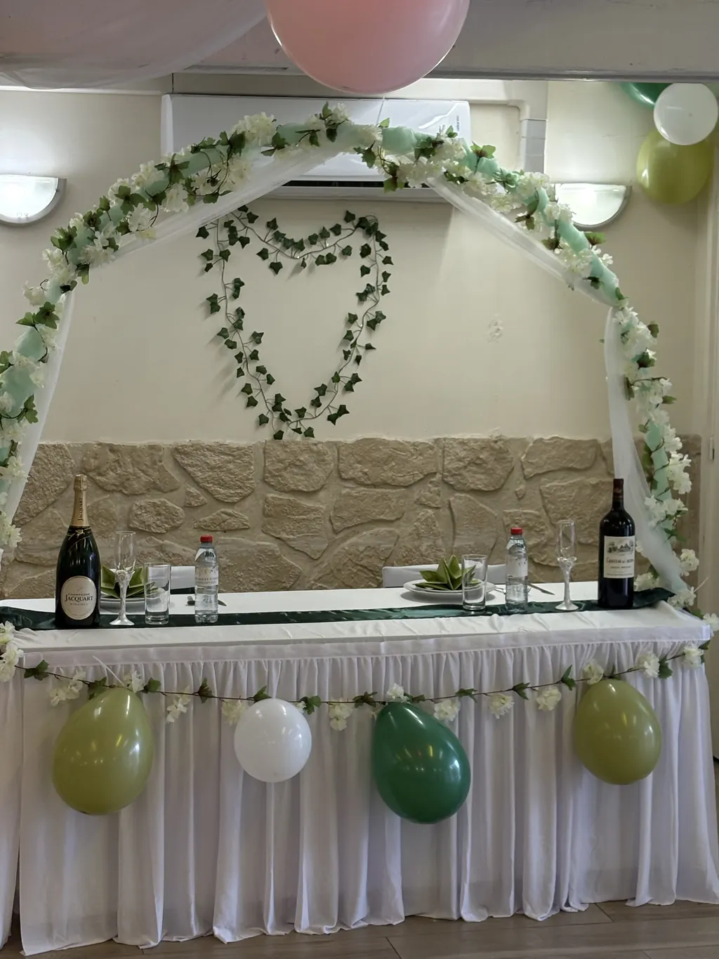Table d'honneur des mariés sous une arche végétale